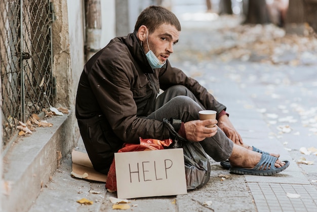 Free Photo Homeless Man Outdoors With Help Sign And Cup