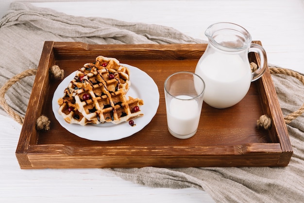 Homemade belgian waffles with fresh milk on wooden tray Free Photo