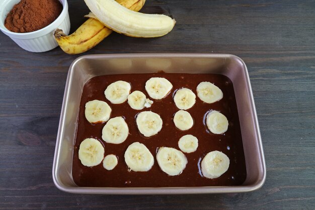 Premium Photo | Homemade dark chocolate banana cake batter in cake pan with baking ingredients ...