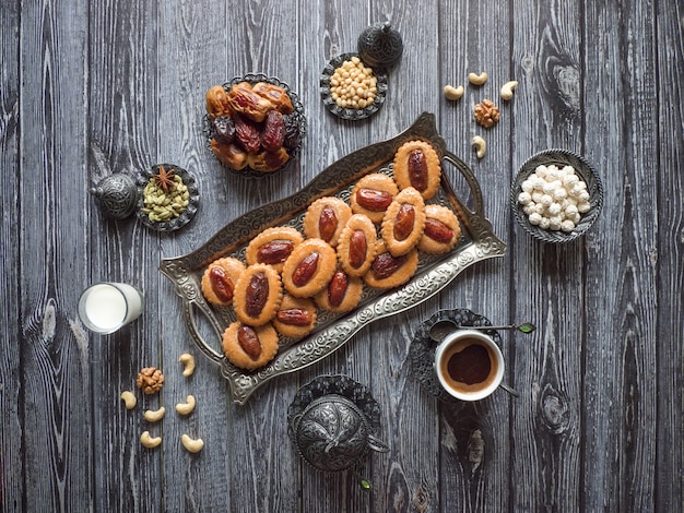 Premium Photo | Homemade eid dates sweets on a black wood table