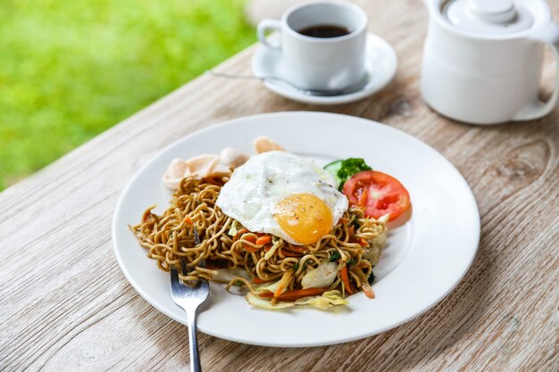 Premium Photo Homemade indonesian fried noodle with a cup of 