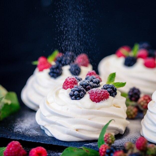 Premium Photo Homemade Meringue Basis For Cake Pavlova With Fresh Blueberries And Blackberry And Powdered Sugar On Black Concrete Texture Surface