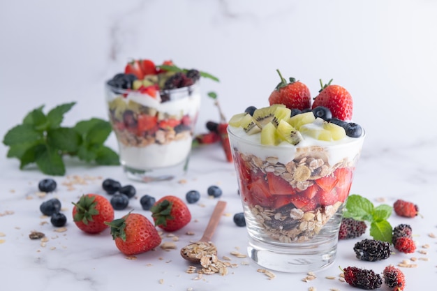 Download Free Photo Homemade Muesli Bowl Of Oat Granola With Yogurt Fresh Blueberries Mulberry Strawberries Kiwi Mint And Nuts Board For Healthy Breakfast Copy Space Healthy Breakfast Concept Clean Eating