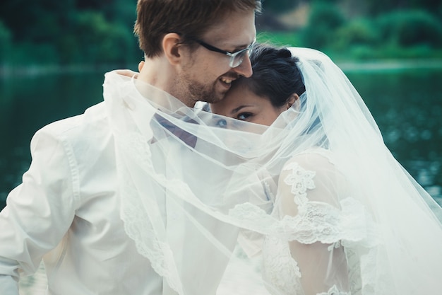 Premium Photo | Honeymoon. the bride and groom hugging on the shore of ...