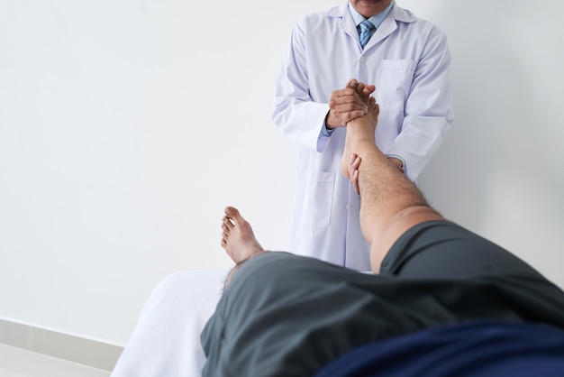stamtavle Perseus Mærkelig Premium Photo | Horizontal shot of unrecognizable osteopathic physician  working with male patient holding his leg doing foot joint manipulation