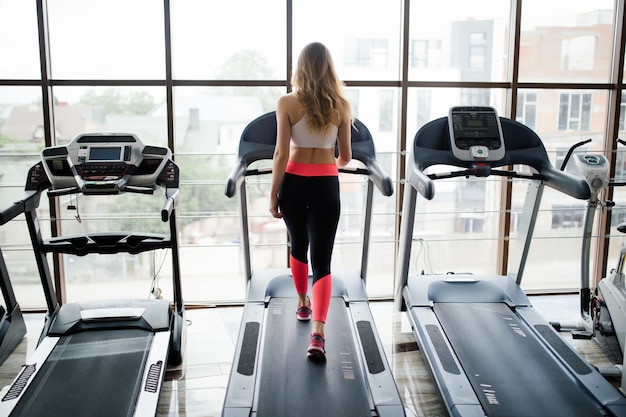 Free Photo Horizontal Shot Of Woman Jogging On Treadmill At Health Club Female Working Out At