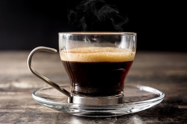 Premium Photo | Hot coffee glass with smoke on wooden table.