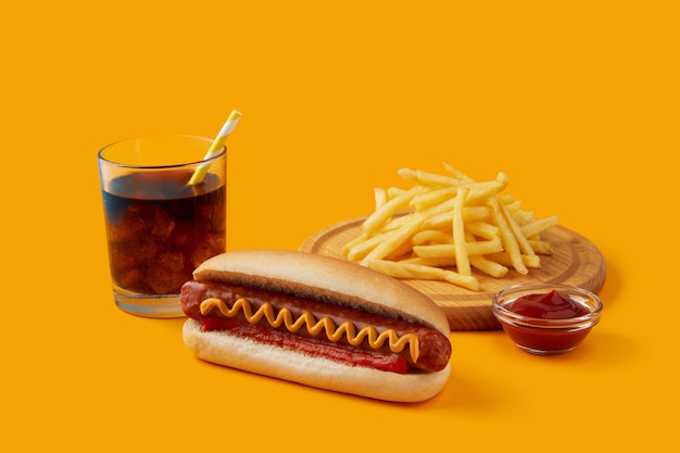 Premium Photo | Hot dog with french fries and soft drink on orange ...