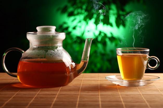 Hot green tea in glass teapot and cup Free Photo