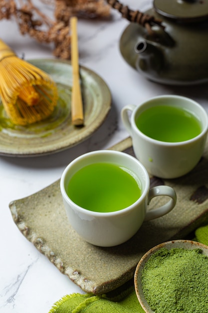 Free Photo Hot green  tea  in a glass  with cream topped 