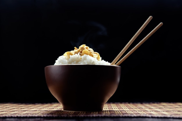 Hot rice with natto in brown bowl with chopsticks in japanese style Premium Photo