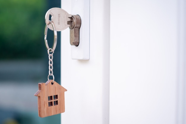 Premium Photo | A house key with a key ring inserted at the door lock ...