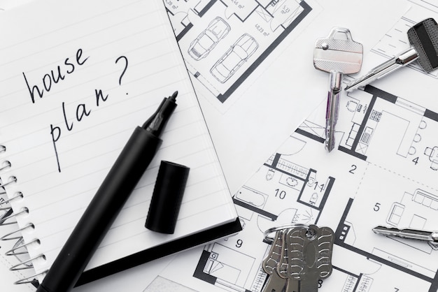House plan with question mark sign written on notebook with felt tip pen and keys on the blue print Free Photo