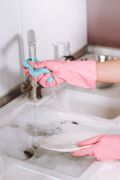 Premium Photo Housewife Girl In Pink Gloves Washes Dishes By Hand In