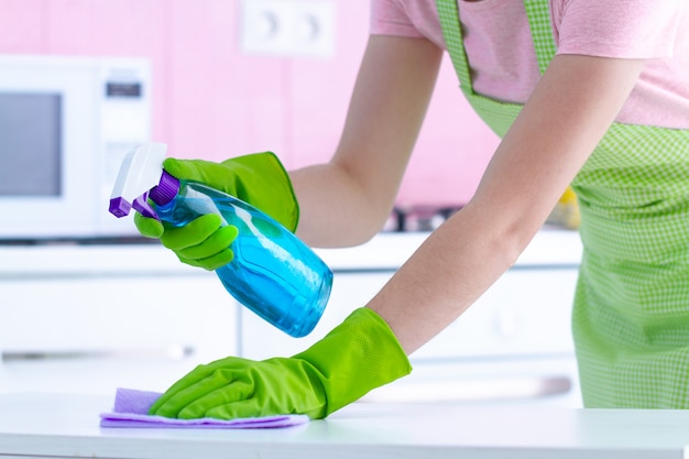 Premium Photo | Housewife in protective rubber gloves wiping dust off ...