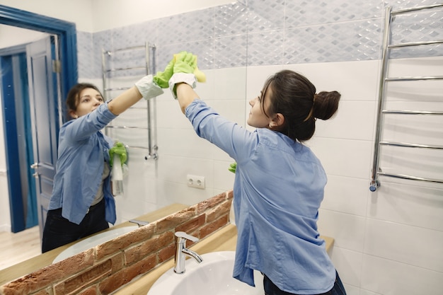 Housewife woking at home. lady in a blue shirt. woman in a bathroom. Free Photo
