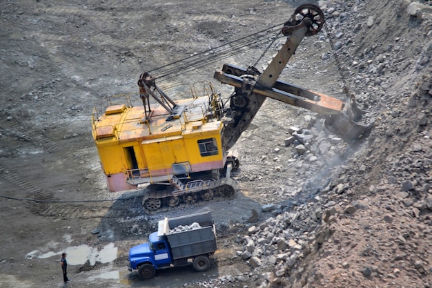 Premium Photo | Huge excavator and a truck on a granite quarry