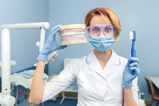 Premium Photo Humor Dentist Holding A Human Jaw And Tooth Brush In Hand Funny Emotion