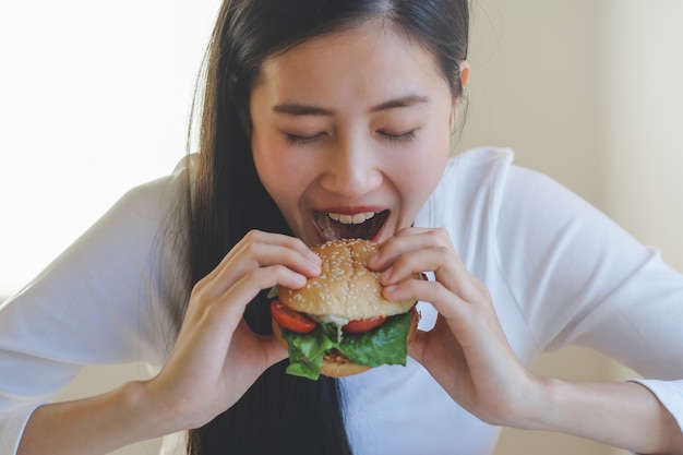 Premium Photo | Hungry asian woman eat burger