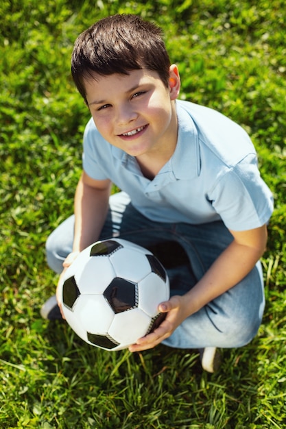 Premium Photo | I love football. joyful dark-haired boy smiling and ...