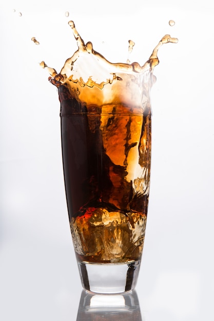 Premium Photo | Ice cube falling into a glass of soda