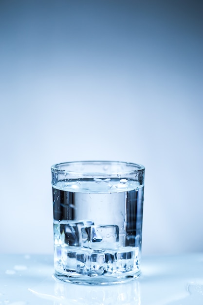 Premium Photo | Ice cube in glass of water isolated on white surface