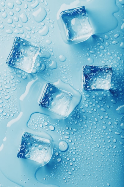 青いテーブル 上面図に溶けた水滴と角氷 蒸し暑い中の鮮度 冷たい飲み物 プレミアム写真
