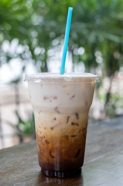 Download Iced coffee latte in takeaway cup on nature bokeh | Premium Photo