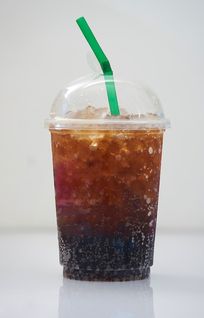 Premium Photo | Iced cola in plastic transparent cup with green straw