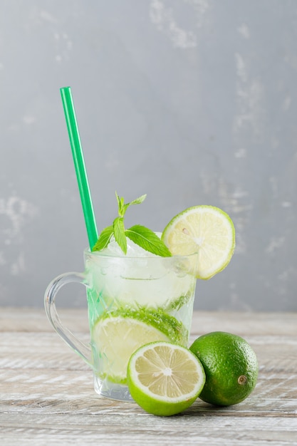 Free Photo | Icy mojito cocktail in a cup with limes, straw, mint side ...