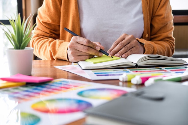 Image of creative graphic designer working on color selection and drawing on graphics tablet Premium Photo