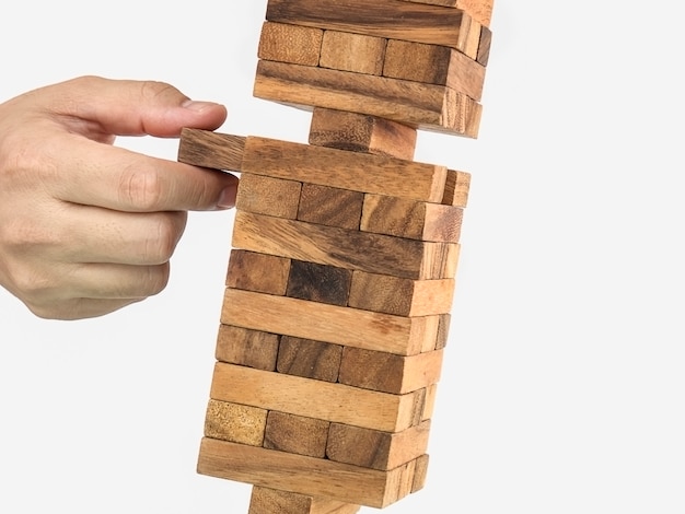 無料の写真 傾斜木製ブロックタワージェンガゲーム 手 リスクの概念