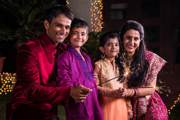 Premium Photo | Indian family in traditional wear playing with ...