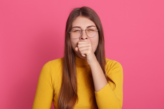 Indoor shot of yawning girl wearing glasses and casual yellow shirt Free Photo
