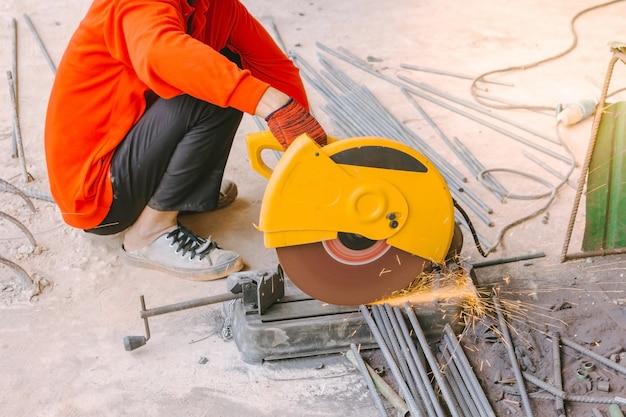 Premium Photo | Industrial worker cutting reinforcing metal rods with