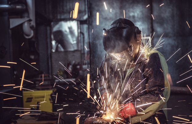 Industrial worker laborer at the factory welding steel structure Premium Photo