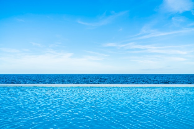 Free Photo | Infinity swimming pool with sea and ocean view on blue sky