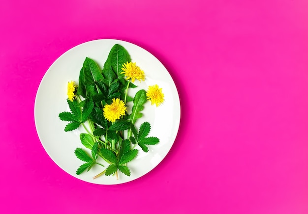 タンポポと食用花を皿に盛り付けた新鮮なグリーンサラダの材料 無料の写真