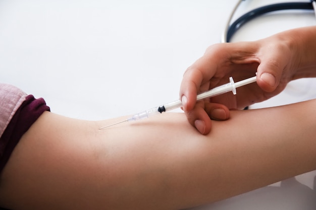 The injecting needle syringe to the patient arm,for vaccination ...