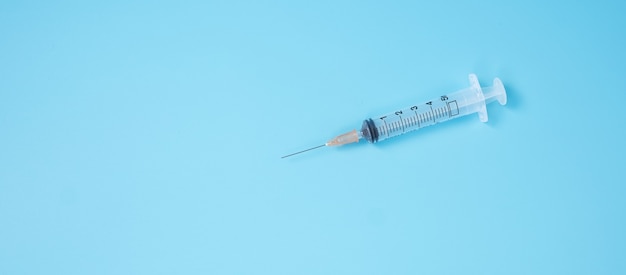 Premium Photo | Injection needle syringe on blue in hospital laboratory ...