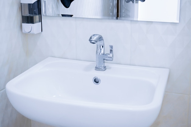 手洗いと鏡付きの公衆トイレの白いきれいなトイレの白いシンクインテリア プレミアム写真