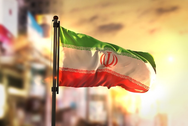 Iran flag against city blurred background at sunrise backlight Premium Photo