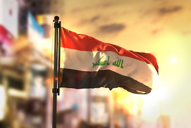 Iraq flag against city blurred background at sunrise backlight Premium Photo