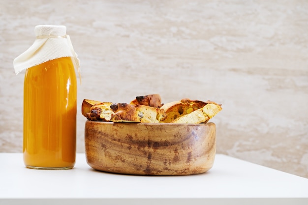 Italian dry biscuits biscotti with nuts, glass bottle of natural fruit juice. simple food, rustic style. Premium Photo