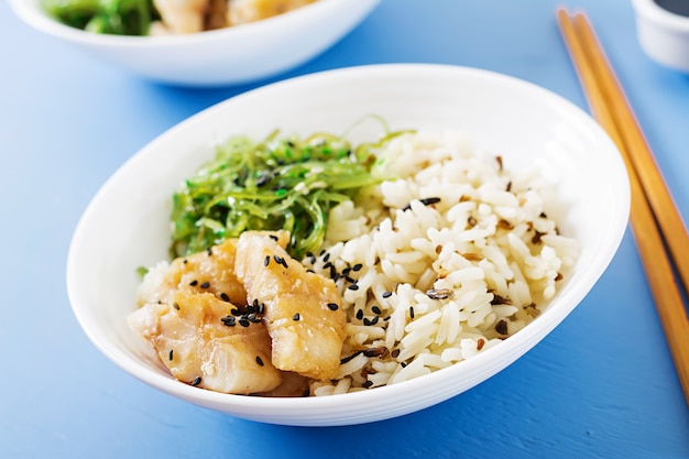Japanese food. bowl of rice, boiled white fish and wakame chuka or