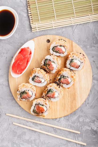 Premium Photo | Japanese maki sushi rolls with salmon on a gray ...