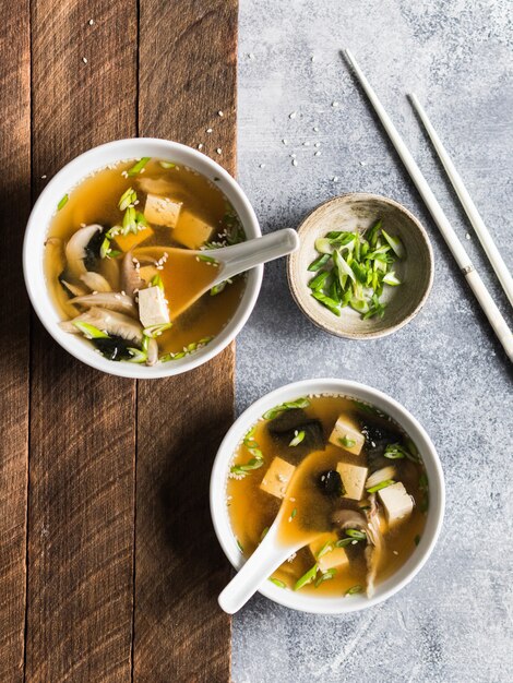 Japanese miso soup with oyster mushrooms in a white bowls with a spoon ...