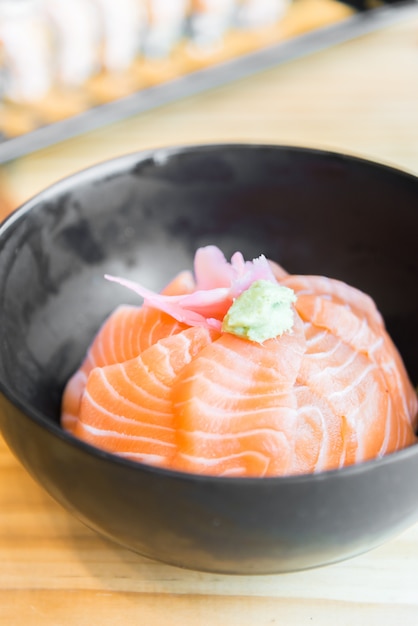 Free Photo | Japanese rice with salmon sashimi on top in black bowl