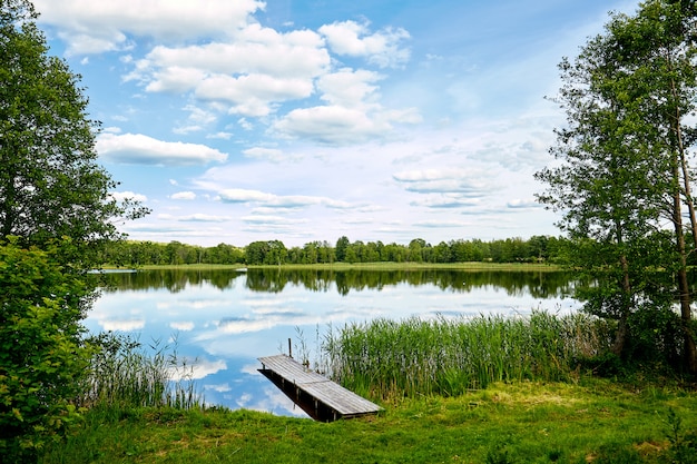 Premium Photo | Jetty on the river, sky reflection in the water