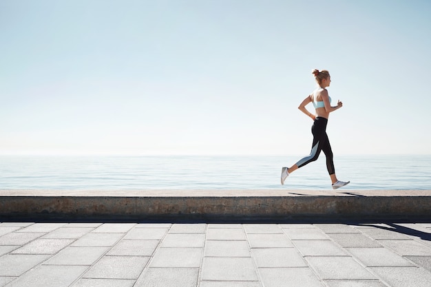 Jogging young woman running on shore Free Photo